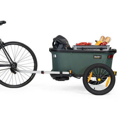 Side view of the Burley Hopper Cargo Trailer, shown attached to a bicycle, with a white background