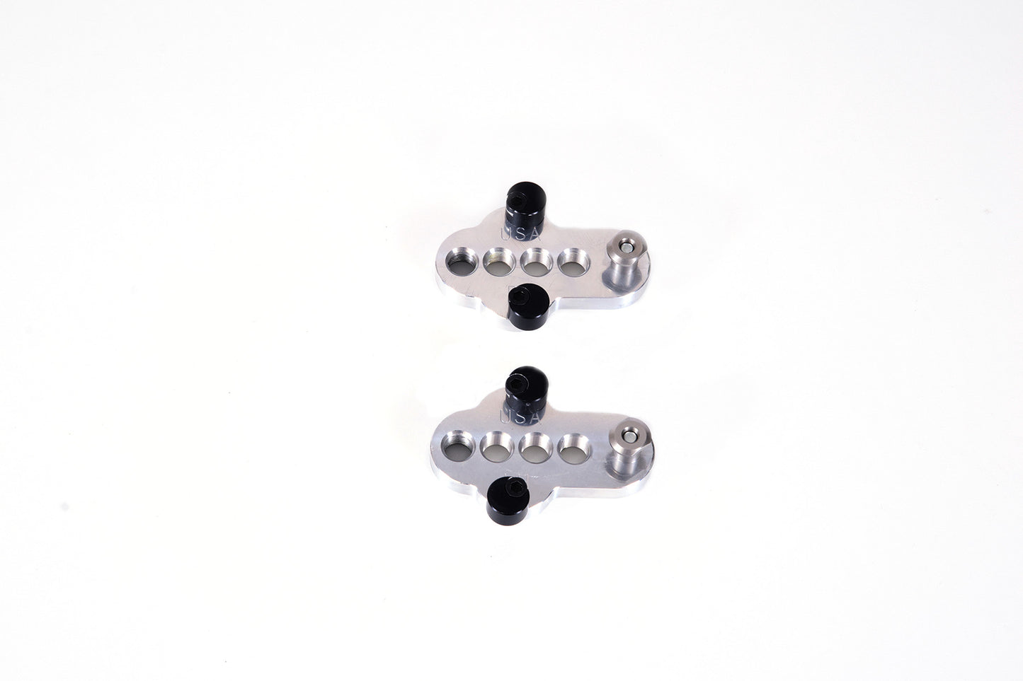 A bottom view of a pair of silver CJ Ackley Machine Company Wide Crank Arm Shorteners.