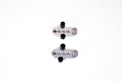 A bottom view of a pair of silver CJ Ackley Machine Company Wide Crank Arm Shorteners.