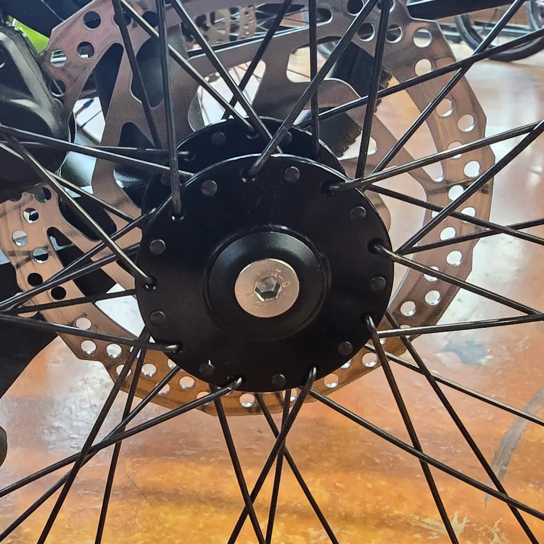 View of the HP Velotechnik Countersunk Screw for Dust Cap mounted on an HP Velotechnik trike hub over the dust cap.