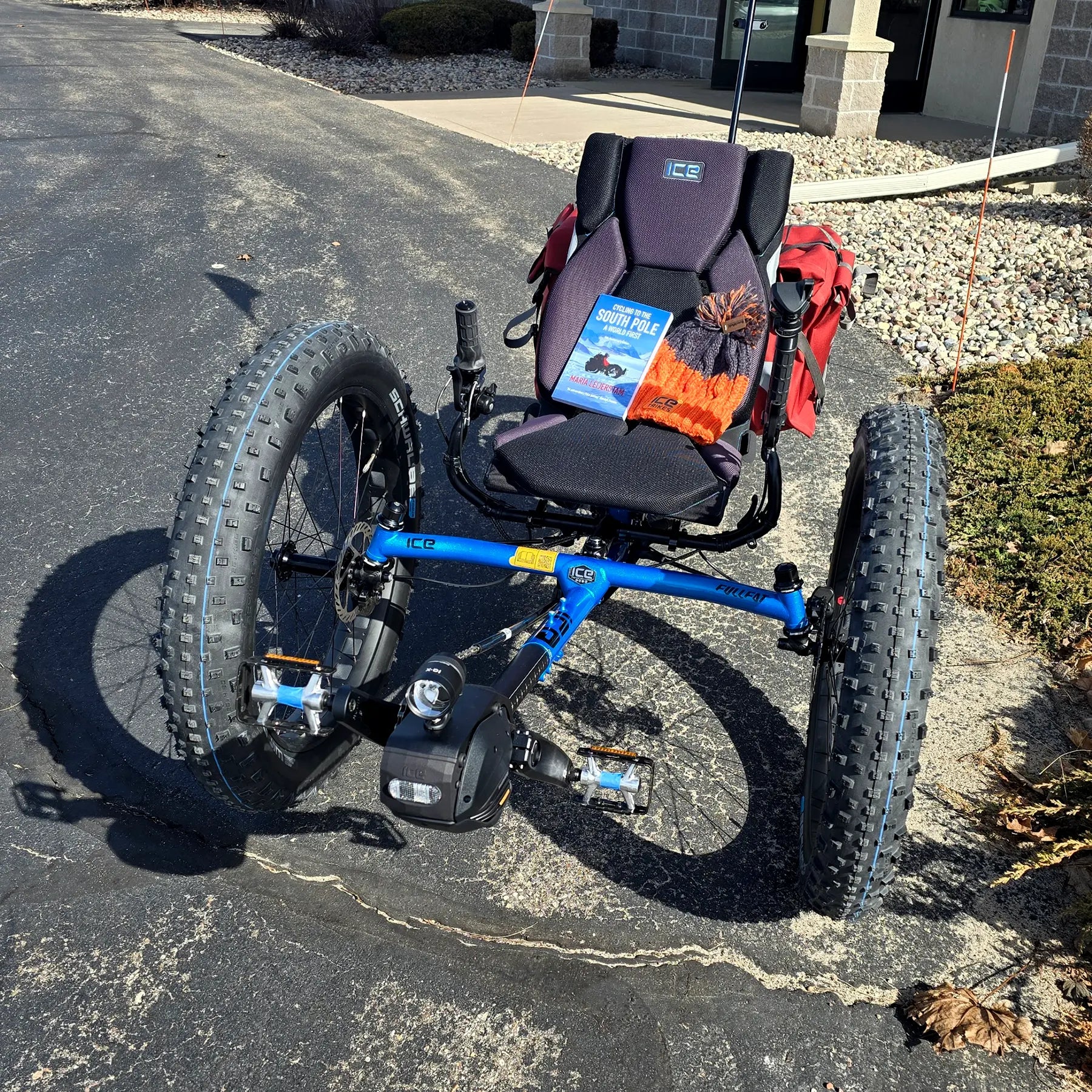 Front view of the ICE Full Fat RS Rohloff Shimano EP8 Hostel Shoppe Limited Edition Custom Blue Recumbent Trike outside in front of the Hostel Shoppe.
