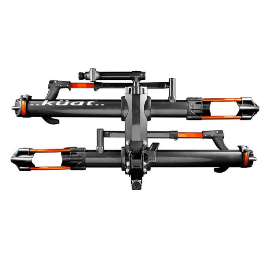 A side view of a Kuat NV 2.0 gray and orange anodized bike rack for two bikes that will fit a 2 inch receiver hitch. 