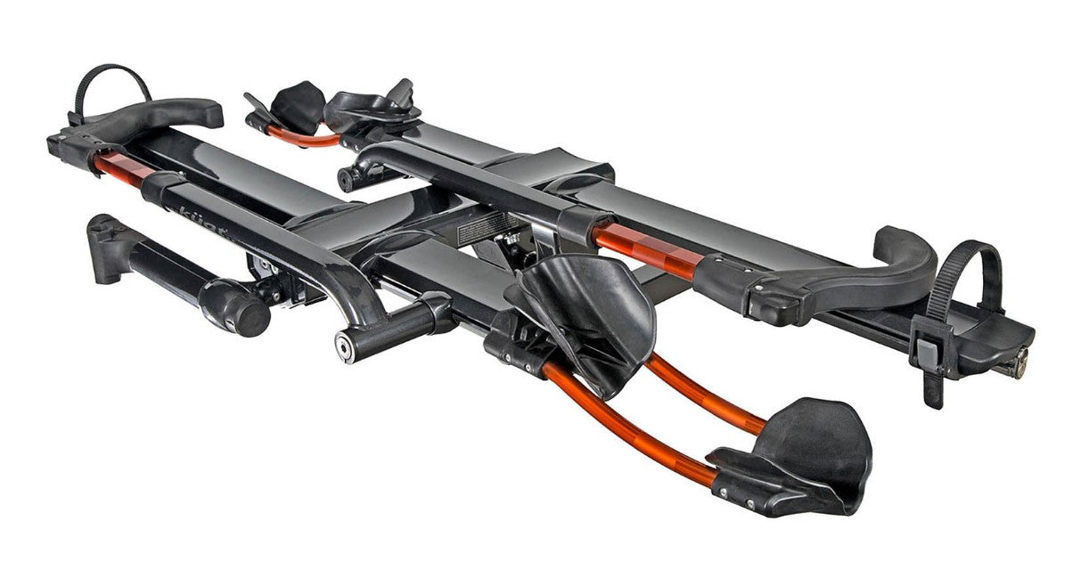 An angled view of a Kuat NV 2.0 gray and orange anodized bike rack for two bikes that will fit a 2 inch receiver hitch. 