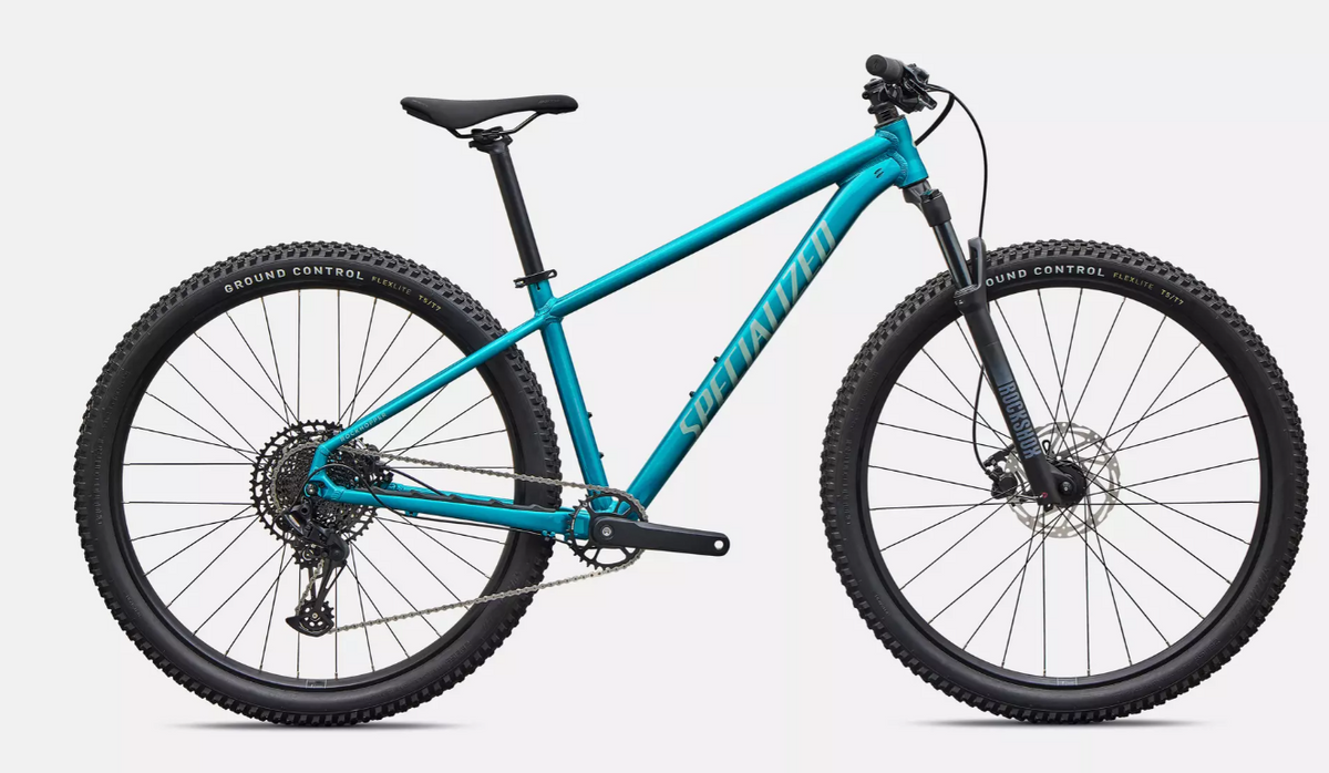 A profile view of a teal Specialized Rockhopper Comp with black tires, seat post and seat, on a white background.