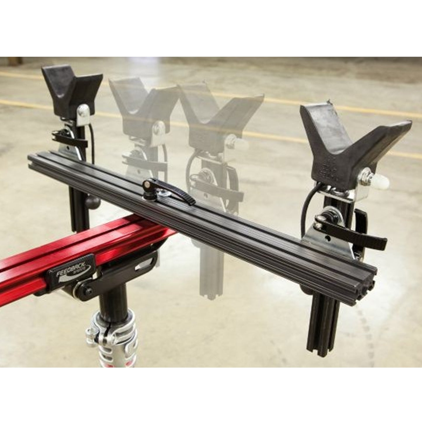 Close-up of moveable supports on a red repair stand against a white background.