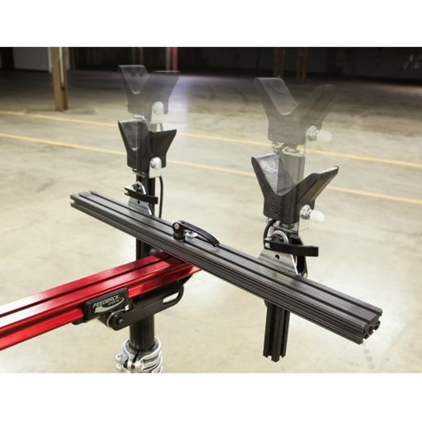 Close-up of moveable vertical supports on a red repair stand against a white background.