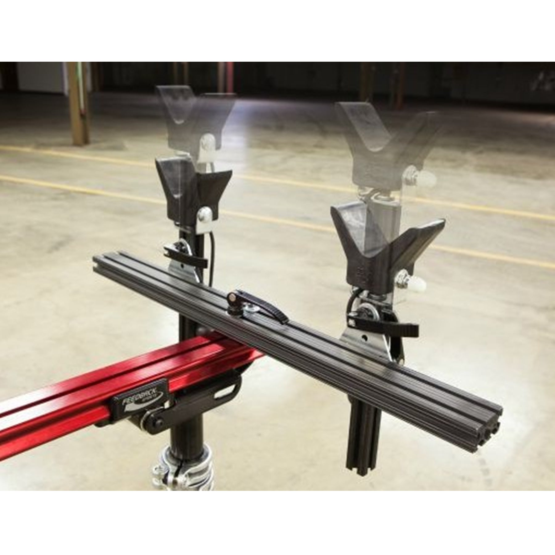 Close-up of moveable vertical supports on a red repair stand against a white background.