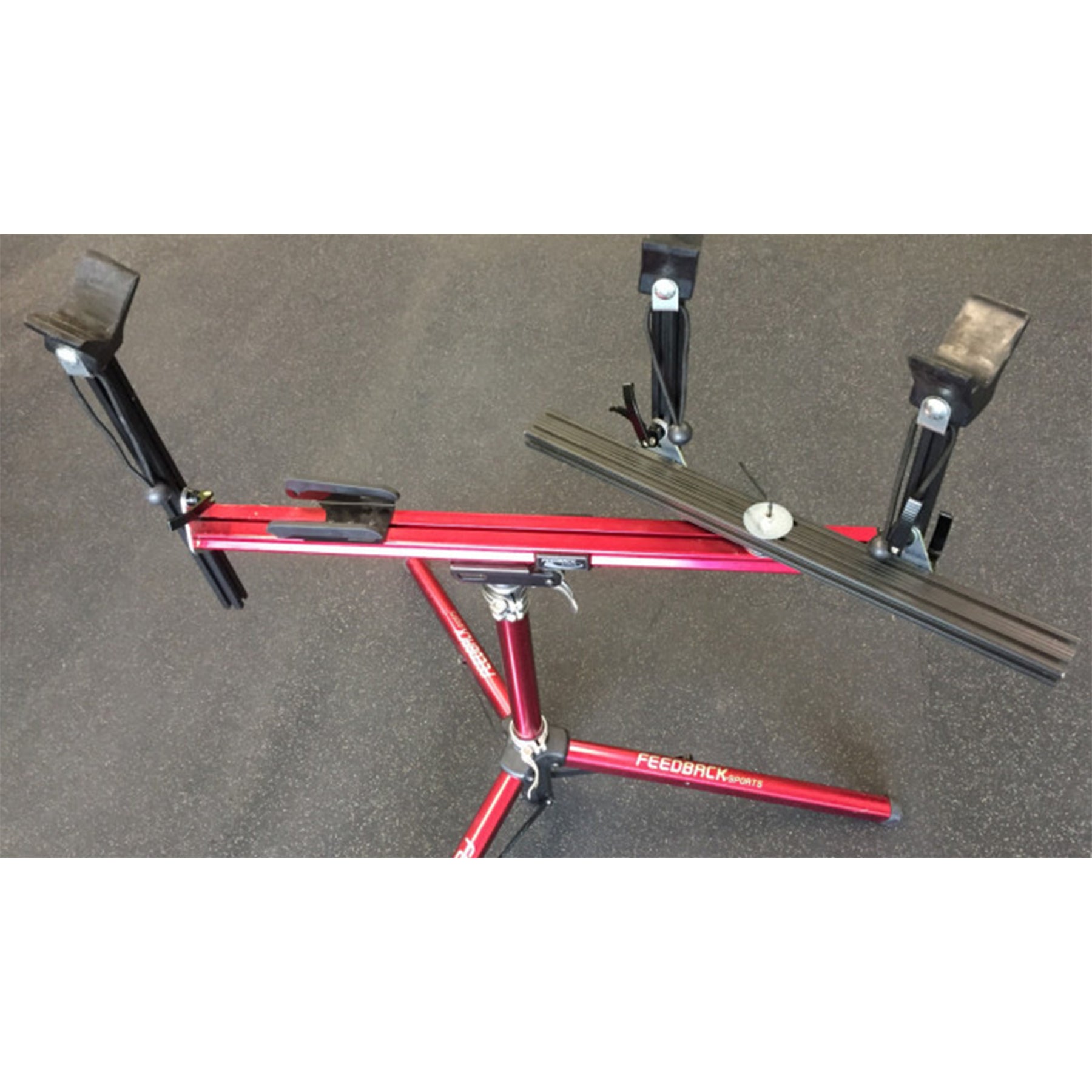 Close-up of moveable supports on a red repair stand against a white background.