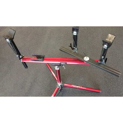 Close-up of moveable supports on a red repair stand against a white background.