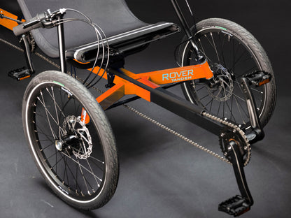 Closeup front view of the TerraTrike Rover Tandem Recumbent Trike in Habanero Orange against a grey background.