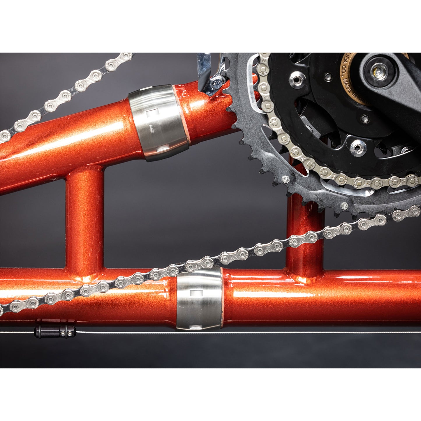 Closeup view of the S&S Couplers on the TerraTrike Tandem Pro Sparkle Copper Recumbent Trike against a grey background.
