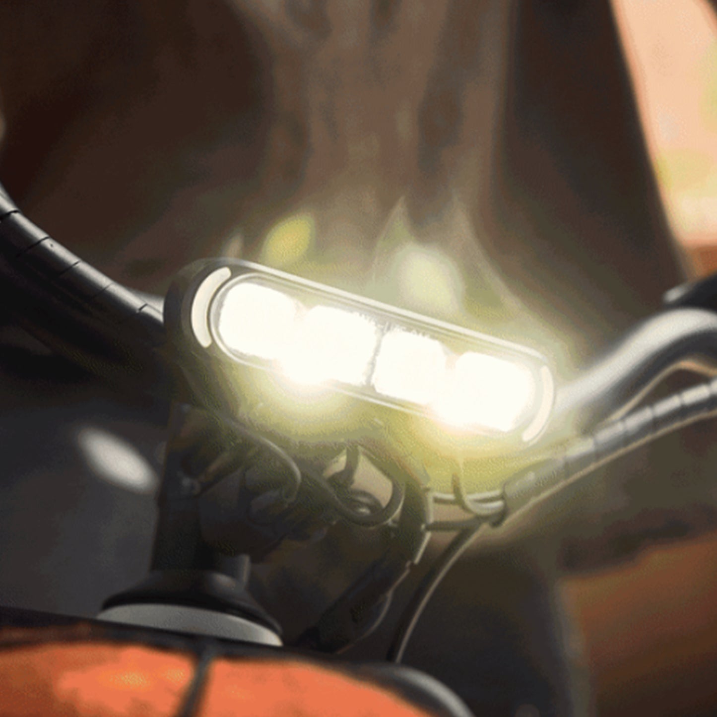 Closeup view of the headlight and handlebars on the Trek Borrego+ S against a blurred out outdoor background.