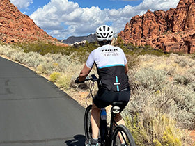 Biker on a Trek Travel Trip a desert road with red rock formations in Zion National Park.