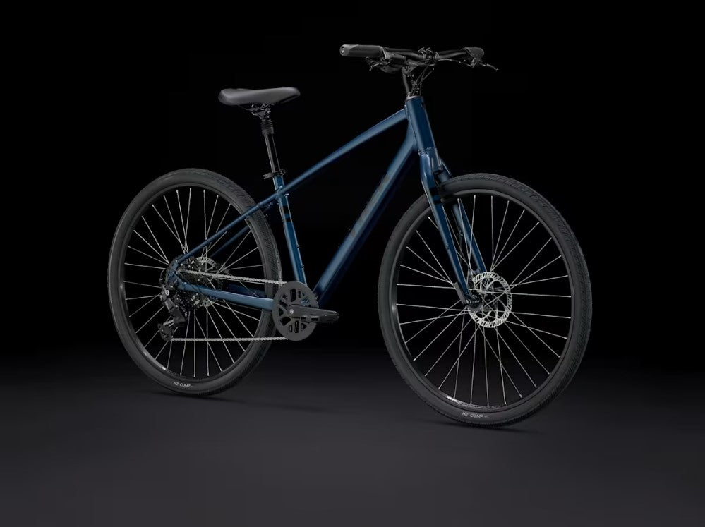 Front right  of blue Trek Verve bicycle with black components on a black background. 