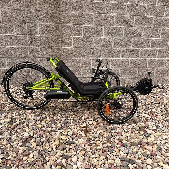 Side view of the Catrike Used 5.5.9 eCat Eon Green Recumbent Trike in an outdoor setting.