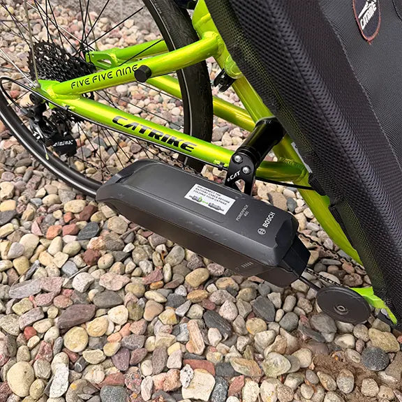 Closeup view of the Bosch battery on the Eon Green Recumbent Trike in an outdoor setting.
