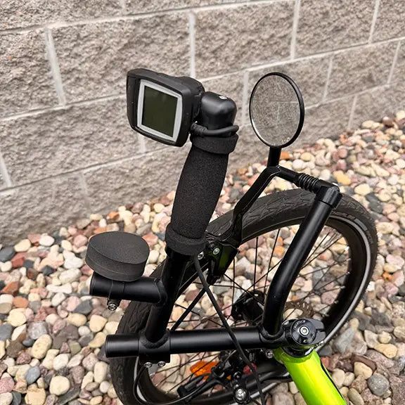 Closeup view of the Bosch e-assist controls, wrist wrest and mirror on the Catrike Used 5.5.9 eCat Eon Green Recumbent Trike in an outdoor setting.