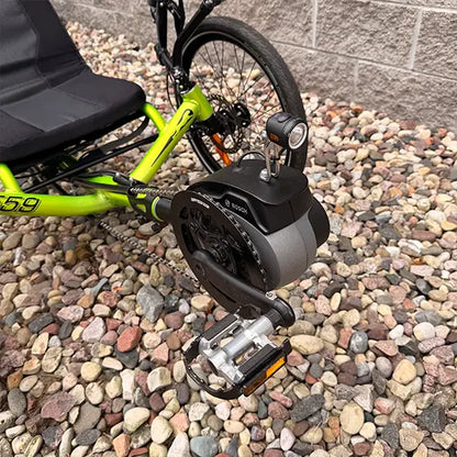 Closeup view of the Bosch motor and headlight on the Catrike Used 5.5.9 eCat Eon Green Recumbent Trike in an outdoor setting.
