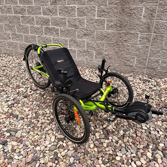 Angled view of the Catrike Used 5.5.9 eCat Eon Green Recumbent Trike in an outdoor setting.