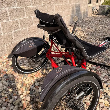 Rear closeup view of the Hase Used Kettwiesel Full Suspension Red Recumbent Trike in an outdoor setting.