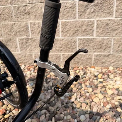 Closeup view of the parking brake on the Hase Used Kettwiesel Full Suspension Red Recumbent Trike in an outdoor setting.