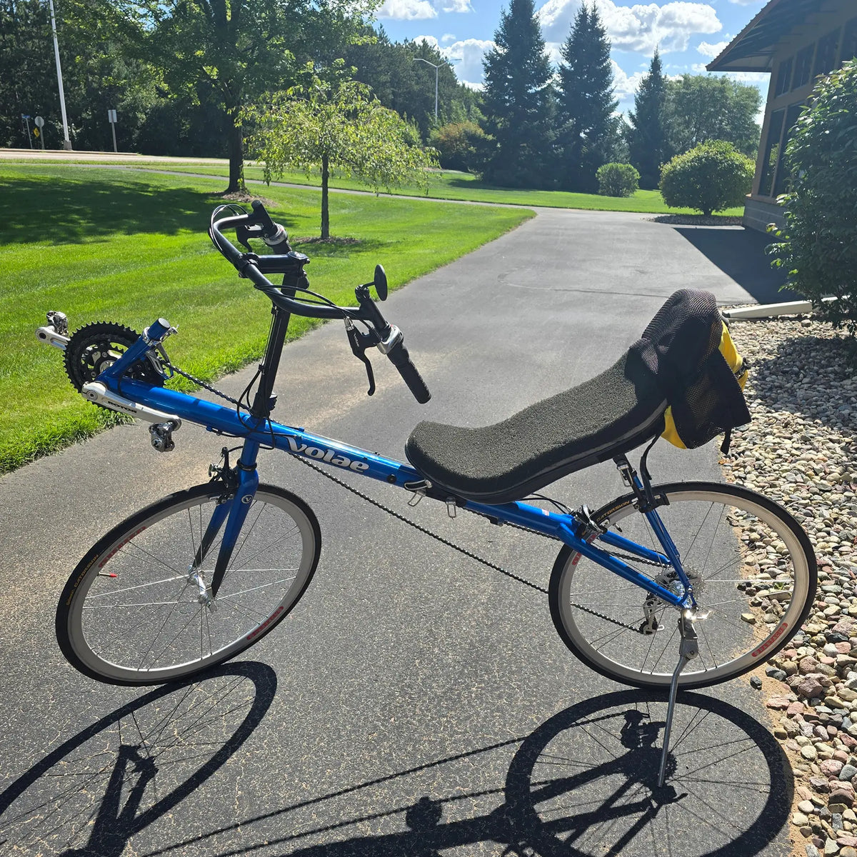 Non-drive side view of the Volae Used Club Dual 650c Blue Small Recumbent Bike in an outdoor setting.