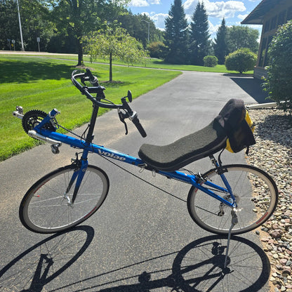 Non-drive side view of the Volae Used Club Dual 650c Blue Small Recumbent Bike in an outdoor setting.