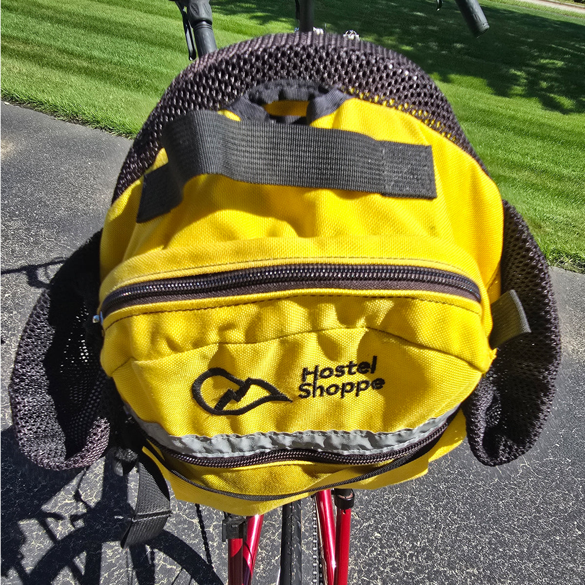 Closeup view of the yellow Hostel Shoppe seat bag on the Used Club Dual 650c Red Large Recumbent Bike in an outdoor setting.