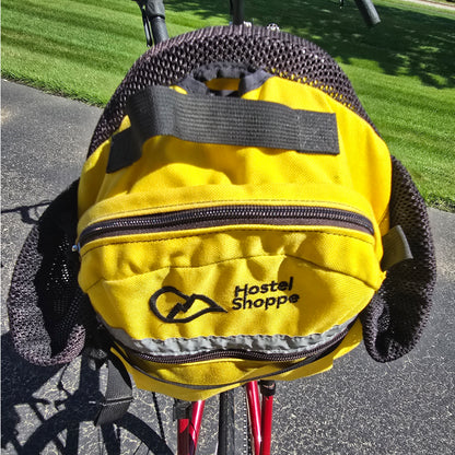Closeup view of the yellow Hostel Shoppe seat bag on the Used Club Dual 650c Red Large Recumbent Bike in an outdoor setting.