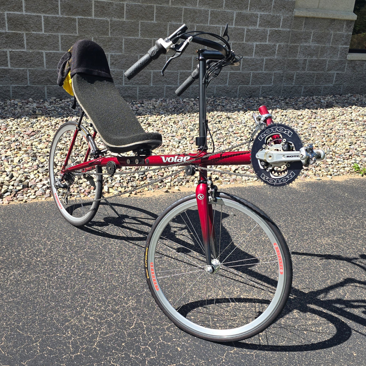 Angled side view of the Volae Used Club Dual 650c Red Large Recumbent Bike in an outdoor setting.