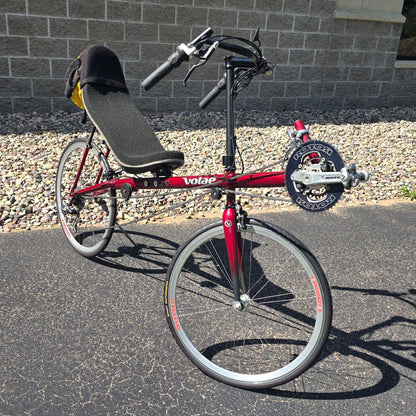 Angled side view of the Volae Used Club Dual 650c Red Large Recumbent Bike in an outdoor setting.
