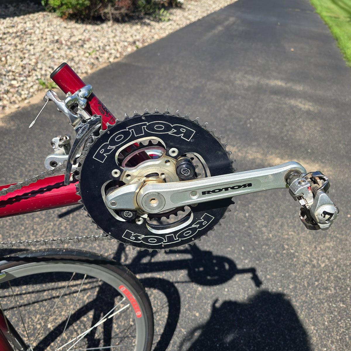 Closeup view of the Rotor Cranks on the Used Club Dual 650c Red Large Recumbent Bike in an outdoor setting.