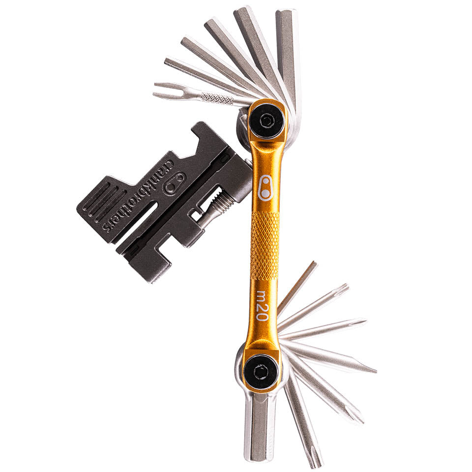 Side studio view of a gold and silver Crank Brothers multi-tool with all tools extended. 