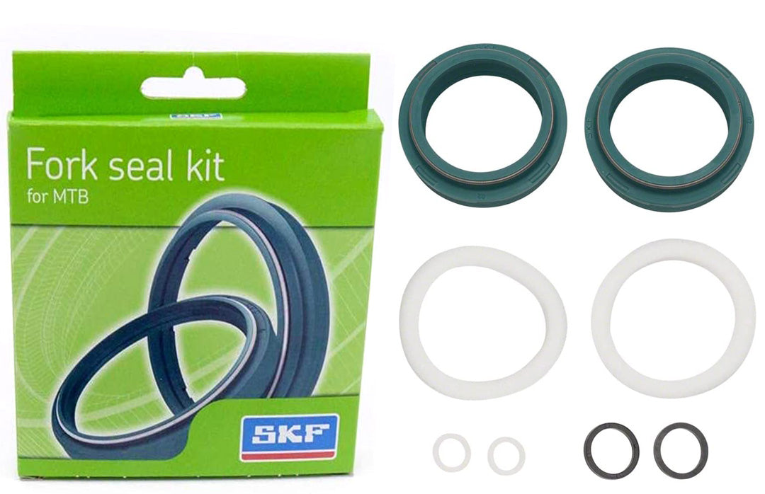 Studio image of box and seals for bicycle fork.  Two large green seals, 2 white large seals, 2 small white seals and 2 medium black seals. 