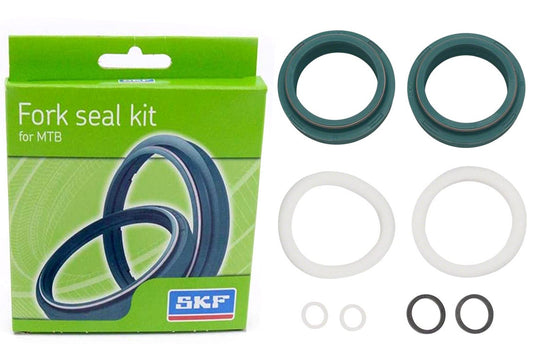 Studio image of box and seals for bicycle fork.  Two large green seals, 2 white large seals, 2 small white seals and 2 medium black seals. 