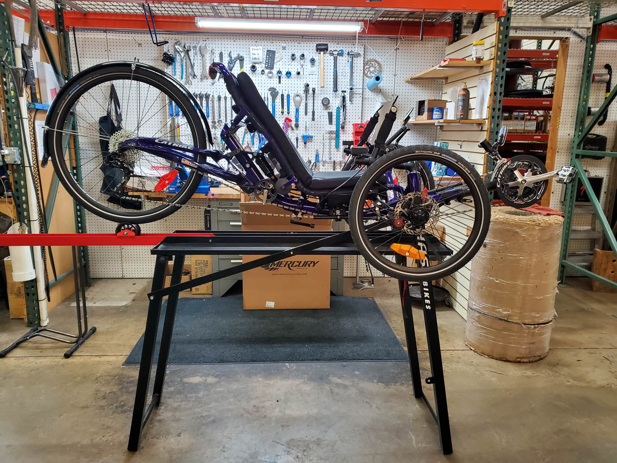 Image of a tadpole style recumbent trike on a Hase Workstand with the rear wheel sitting on the wheel adapter.